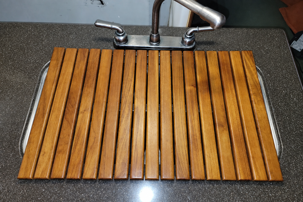 Roll-up teak mat beside an RV shower